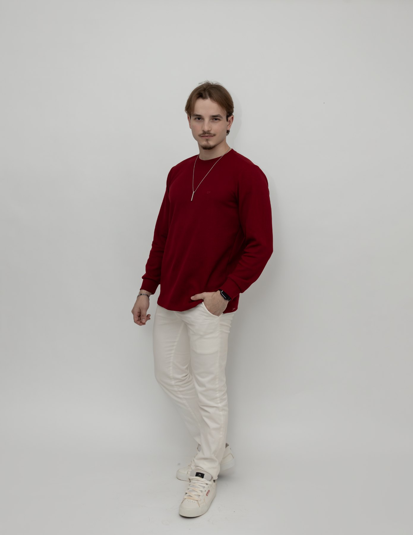 Igor de blusa vermelha e calça clara, corpo inteiro
